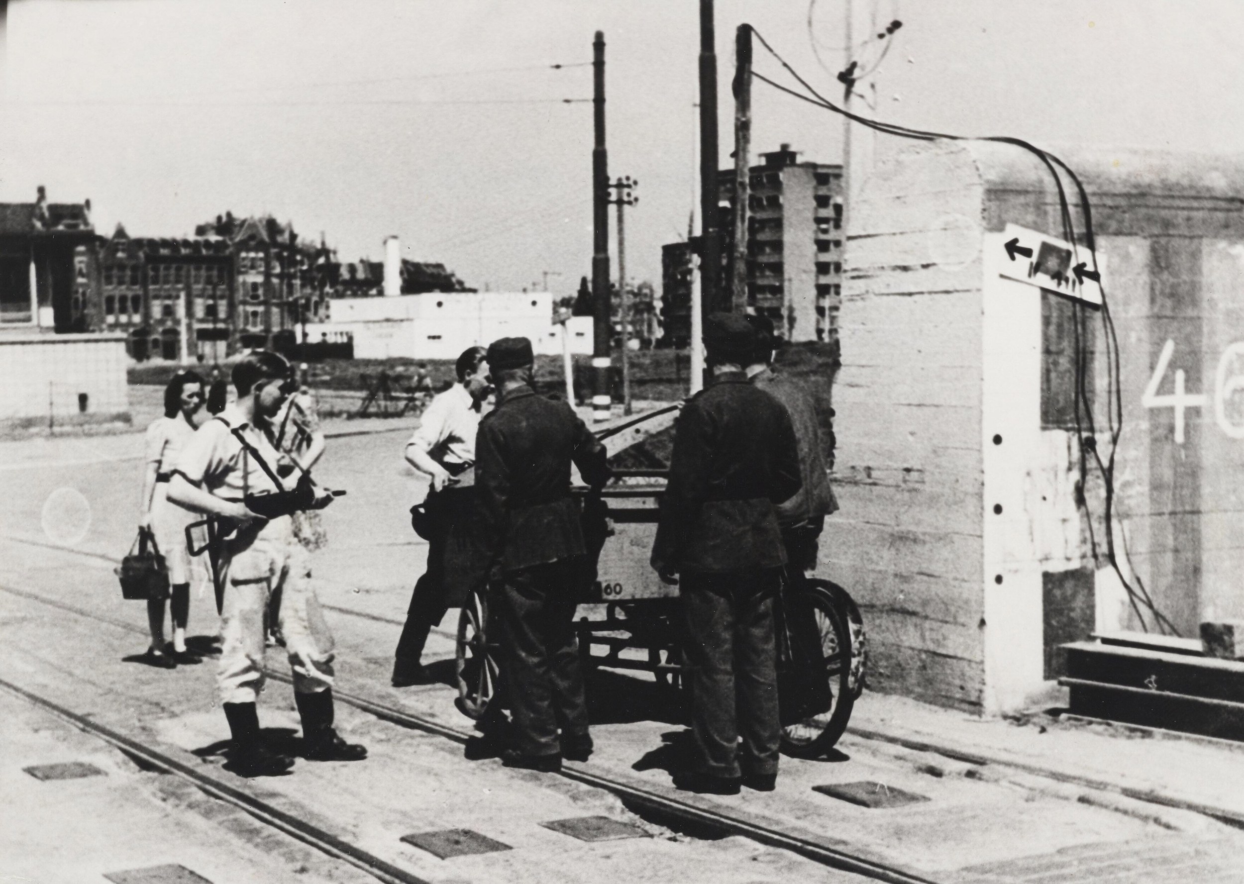 Terugtrekkende Duitse militairen met een bakfiets worden bij doorgang 468 in de Duitse antitankmuur op de G.J. de Jonghweg aangehouden en gecontroleerd door bewapende leden van de BS